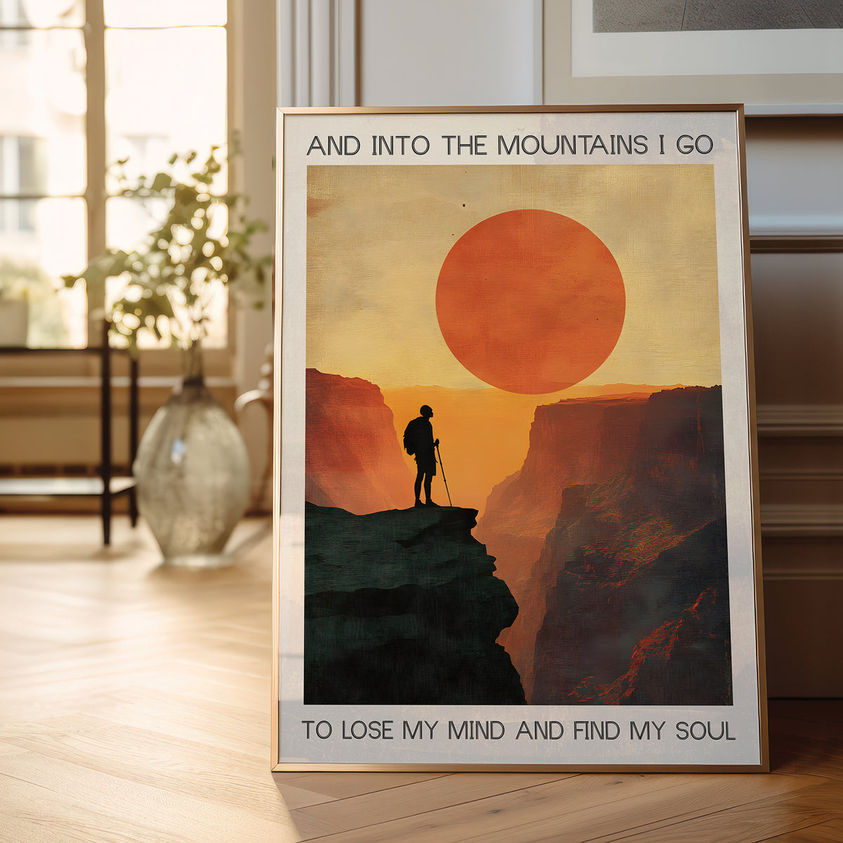 Framed poster of a mountain scene with a person and text in a room.