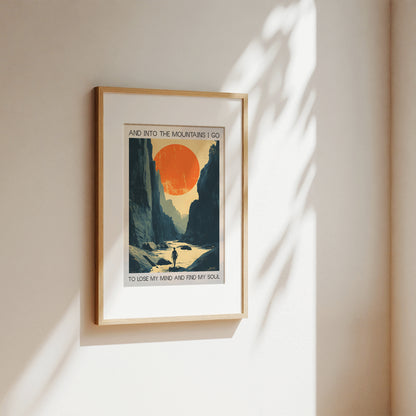 Framed artwork with a scenic design of a sunset over mountains, mounted on a wall.