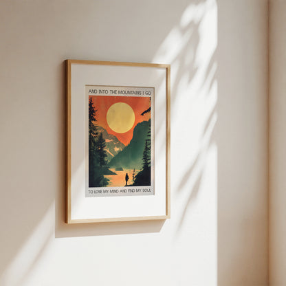 Framed poster with a mountain scene and sunset on a beige wall.