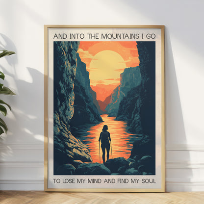 Framed poster of a mountain landscape with a person walking along a river, featuring text 'And into the mountains I go to lose my mind and find my soul'.