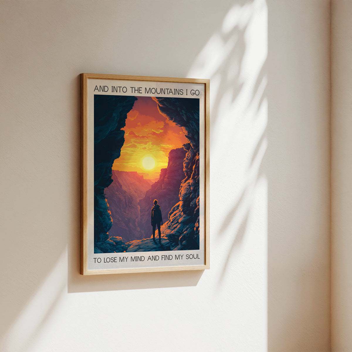 Framed poster of a mountain scene with a person and text on a wall.