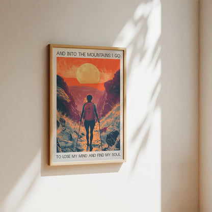 Framed poster of a mountain scene with a person walking, featuring text on a beige wall.