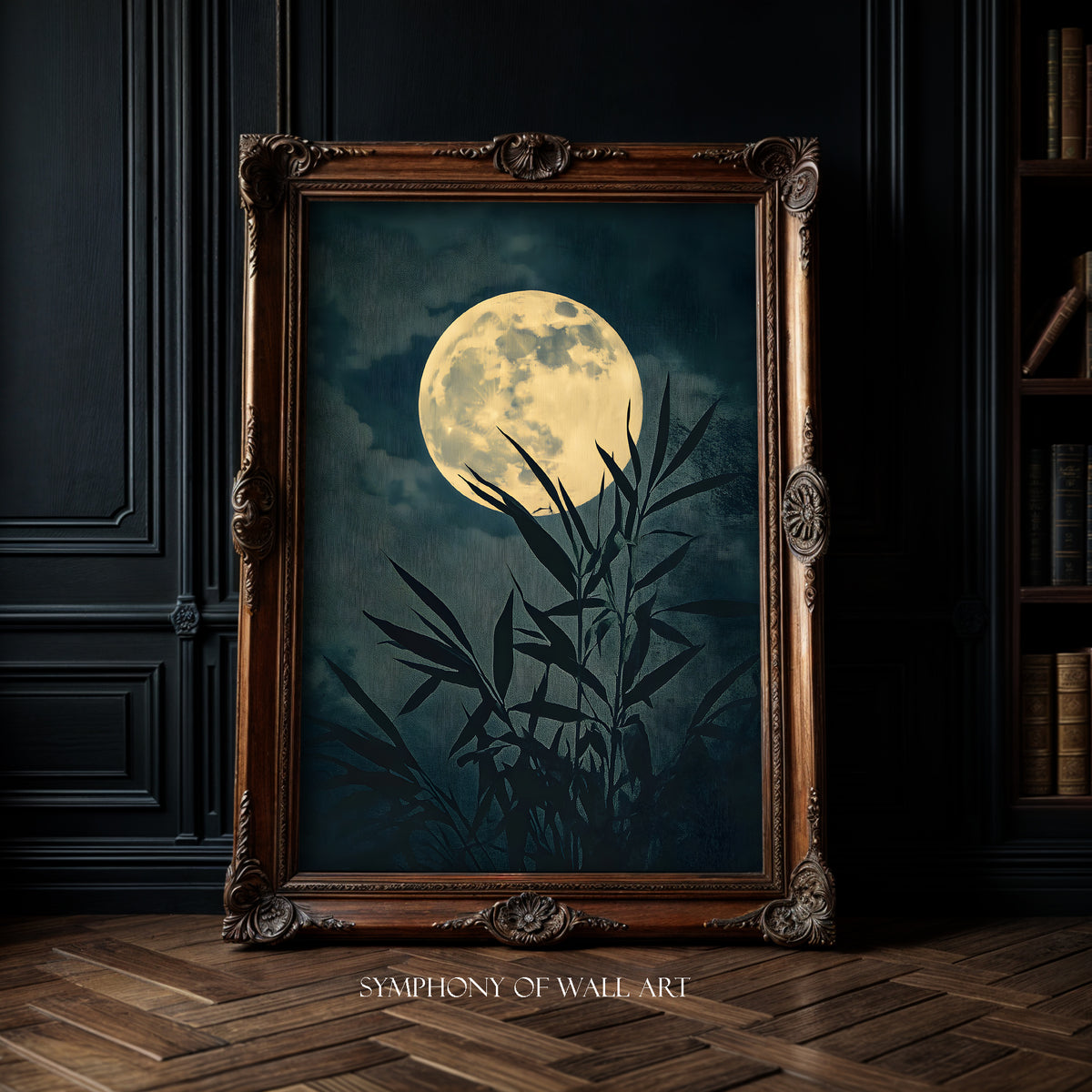 Framed artwork of a moon and bamboo silhouette on a dark background, displayed in a room with wooden floor and bookshelf.