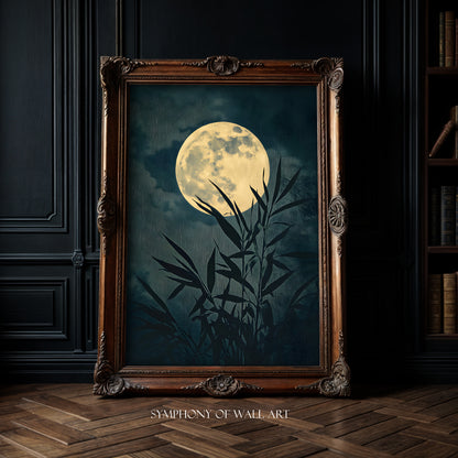 Framed artwork of a moon and bamboo silhouette on a dark background, displayed in a room with wooden floor and bookshelf.