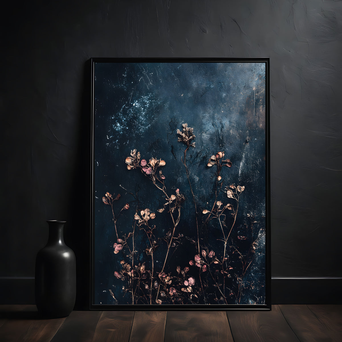 Framed artwork with floral design on a dark textured background, placed on a wooden surface against a black wall.