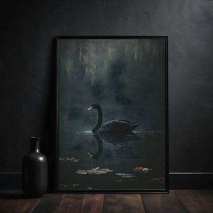 Framed artwork of a swan on water with a dark background, placed on a wooden surface against a dark wall.