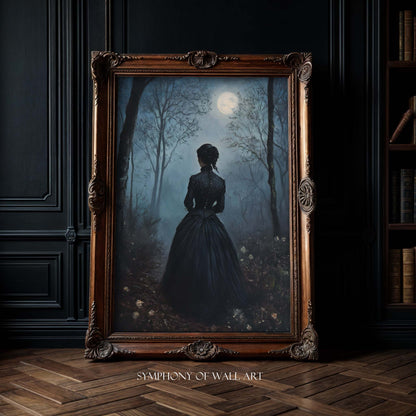 Framed artwork of a woman in a dark dress standing in a forest with a full moon, displayed on a dark wall.