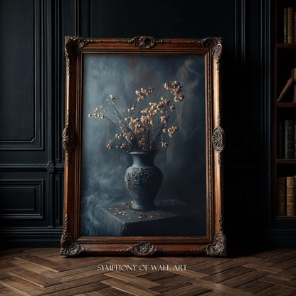 Framed painting of a vase with flowers on a dark background, displayed in a room with wooden floor and bookshelf.