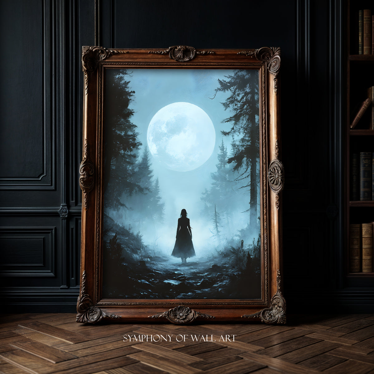 Framed artwork of a silhouette under a moonlit sky with trees, displayed in a room.