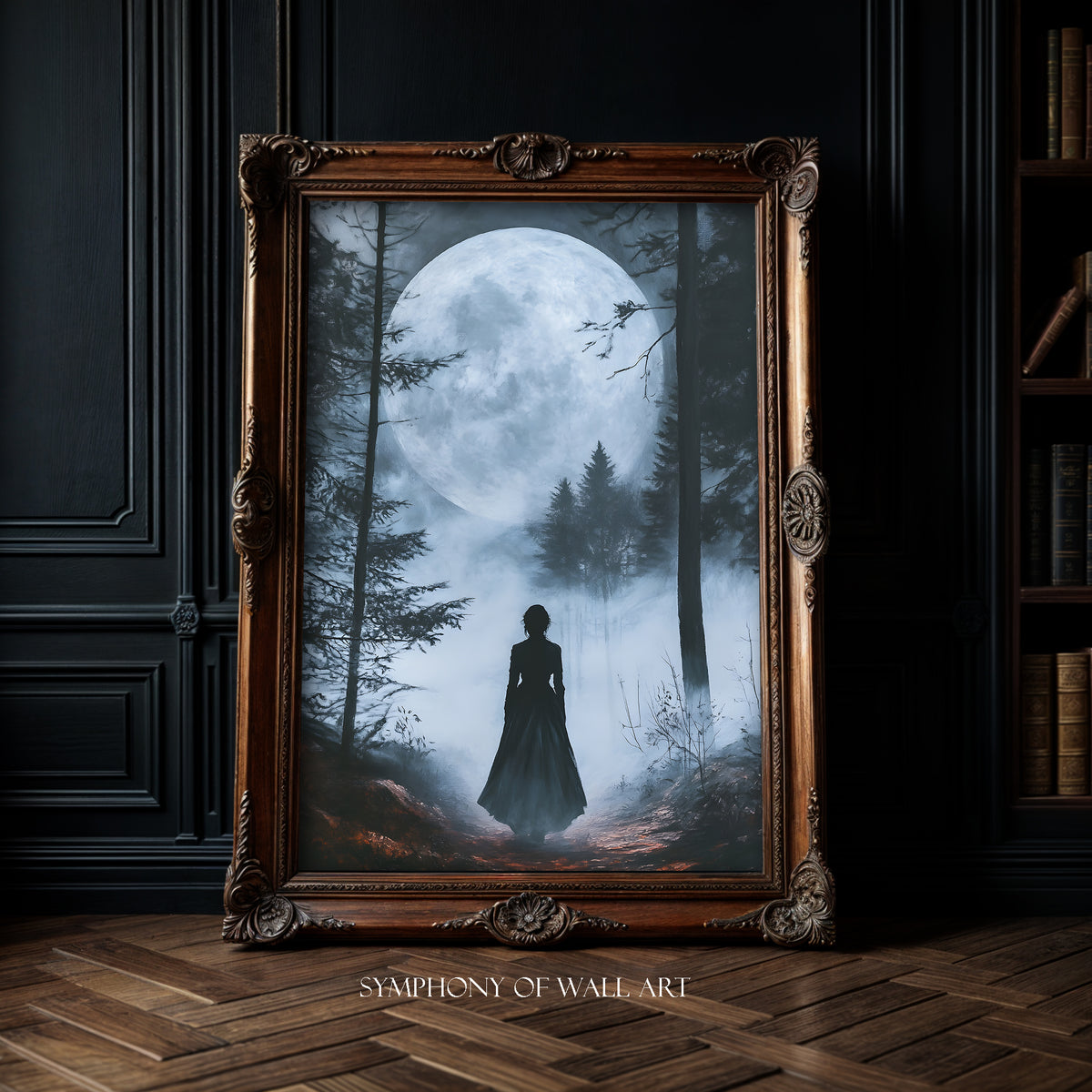 Framed artwork of a silhouette in a forest with a large moon, displayed in a room with dark walls and wooden floor.
