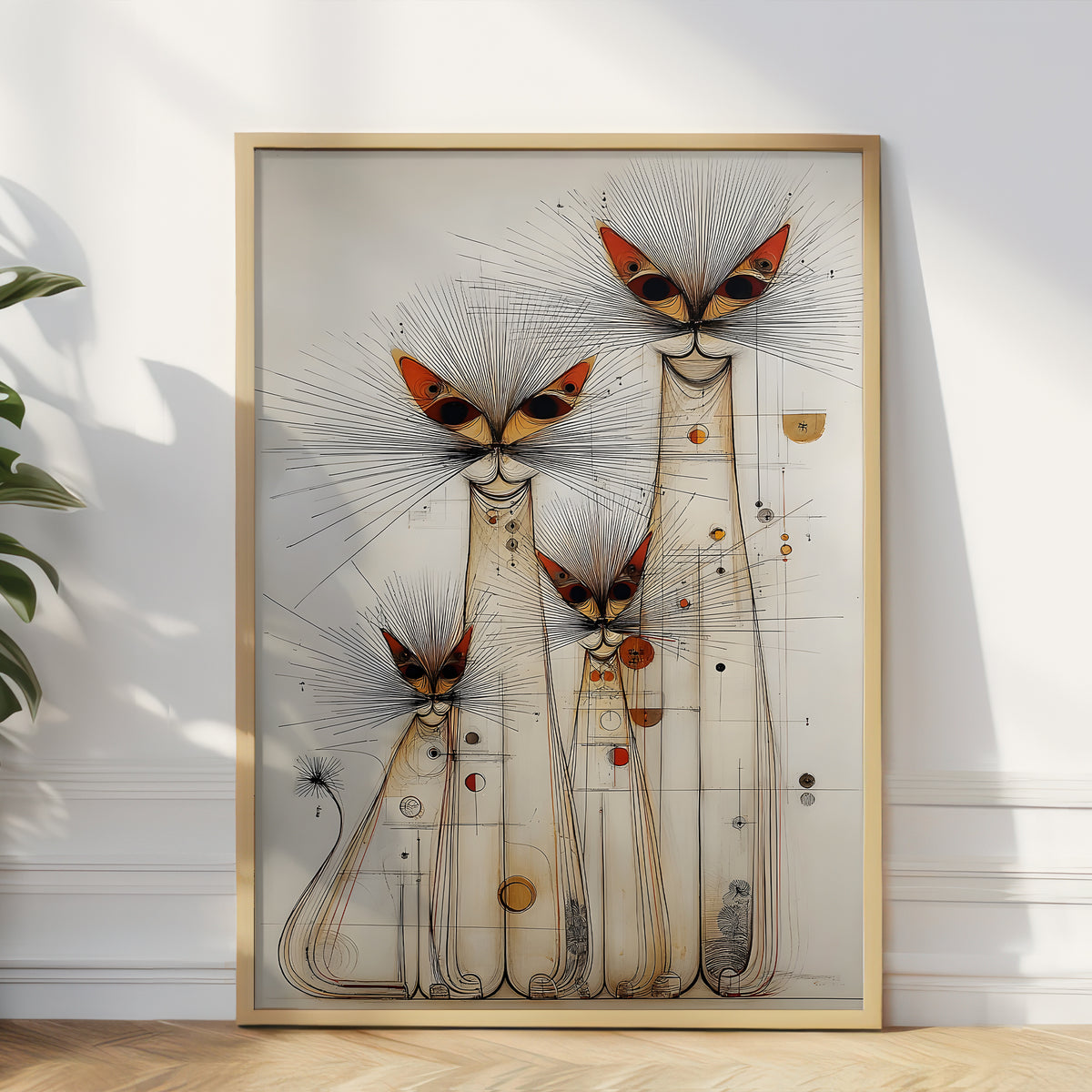 A framed abstract art print featuring stylized cat-like figures with butterfly-like heads, displayed against a white wall on a light wood floor with a plant leaf visible at the left edge.
